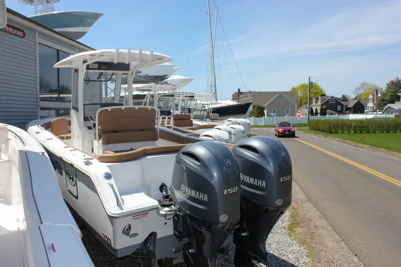 Slide: The Image of 2021 Sea Hunt Ultra 265 SE boat with dual Yamaha engines parked near a road. - 8