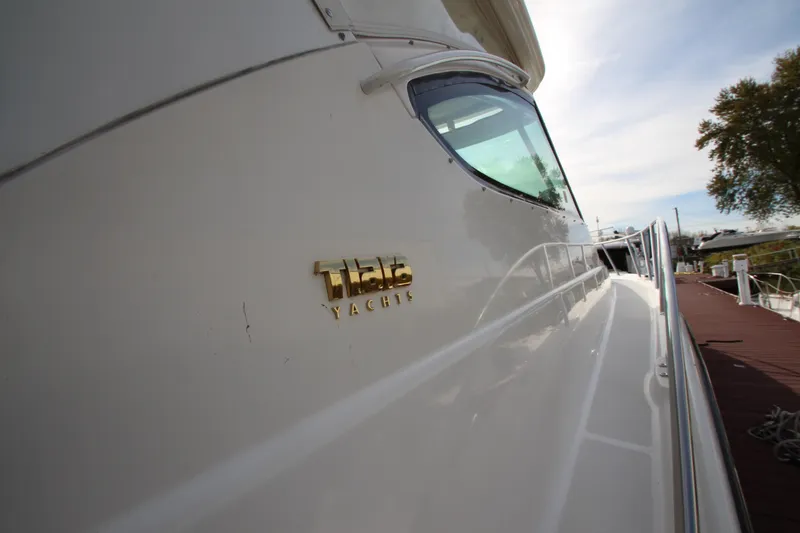 Slide: The Image of 2007 Tiara Yachts 4200 Open, side view with logo, docked under clear sky. - 16