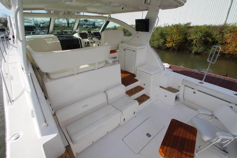 Slide: The Image of 2007 Tiara Yachts 4200 Open interior with seating and helm, docked by greenery. - 25