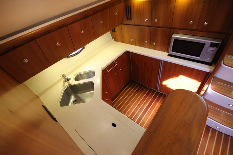 Slide: The Image of 2007 Tiara Yachts 4200 Open kitchen with wood cabinetry, sink, and microwave. - 47