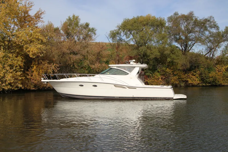 Slide: The Image of 2007 Tiara Yachts 4200 Open cruising on a calm river with autumn trees. - 5