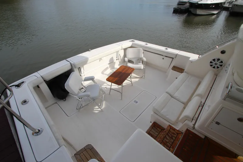 Slide: The Image of 2007 Tiara Yachts 4200 Open, spacious deck with seating and table, docked by the water. - 8