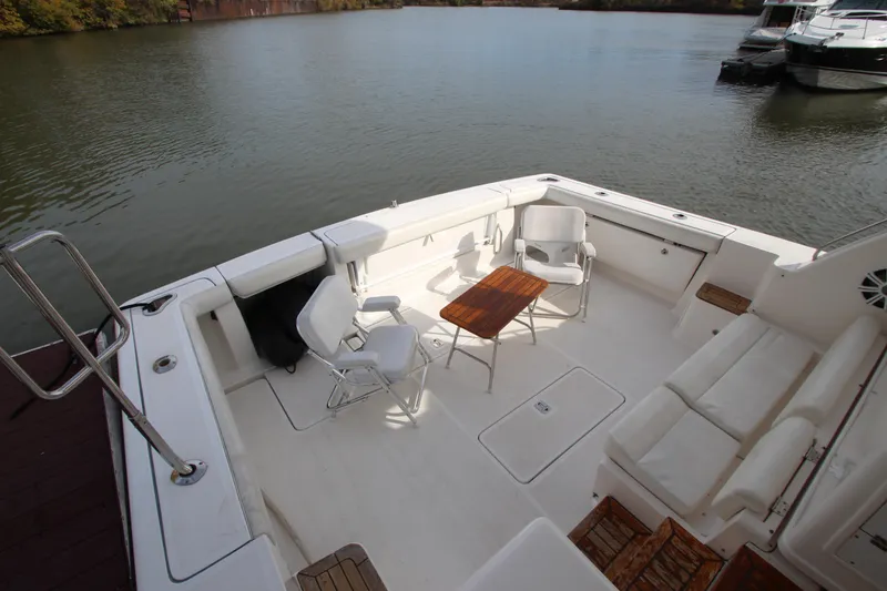 Slide: The Image of 2007 Tiara Yachts 4200 Open deck with seating and table, docked on calm water. - 9