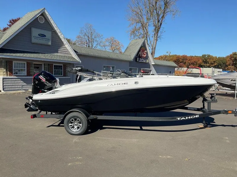 Slide: The Image of 2025 Tahoe T18 boat on trailer, parked outside dealership on sunny day. - 1