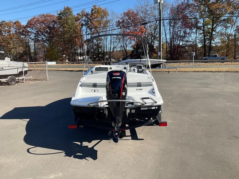 Slide: The Image of 2025 Tahoe T18 boat with outboard motor, parked on pavement, surrounded by autumn trees. - 4