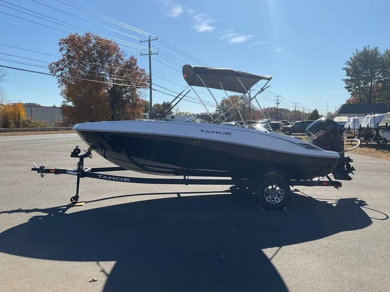 Slide: The Image of 2025 Tahoe T18 boat on trailer, parked outdoors under clear sky. - 6