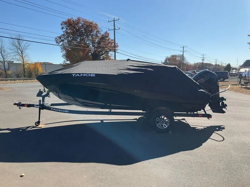Slide: The Image of 2025 Tahoe T18 boat covered on trailer in sunny outdoor setting. - 7