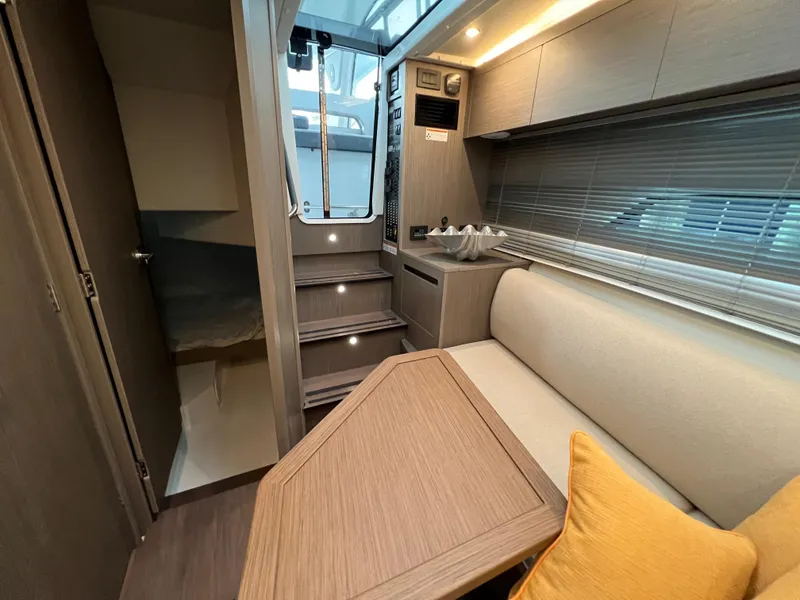 Slide: The Image of Interior of 2025 Beneteau Gran Turismo 36 yacht, featuring modern seating and wooden table. - 15