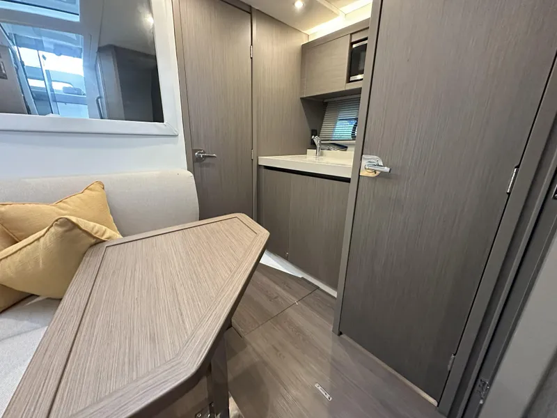Slide: The Image of Interior of 2025 Beneteau Gran Turismo 36 yacht, featuring modern kitchen and seating area. - 16