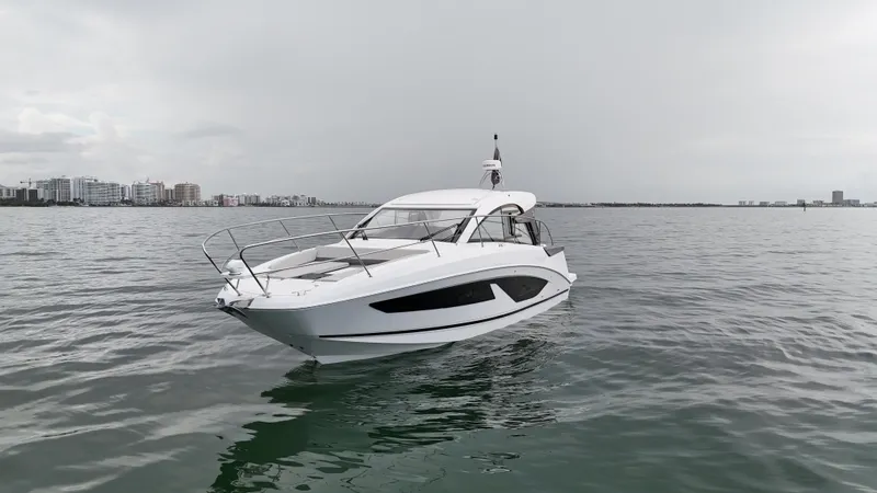 Slide: The Image of 2025 Beneteau Gran Turismo 36 yacht on calm waters, city skyline in background. - 2