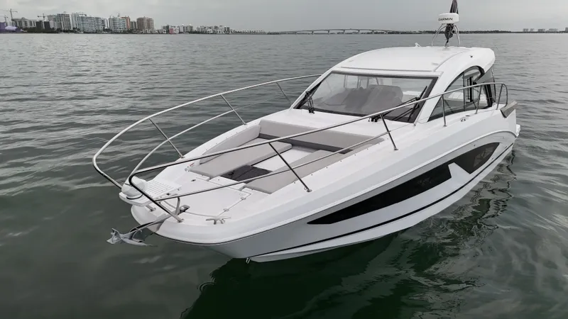 Slide: The Image of 2025 Beneteau Gran Turismo 36 yacht on calm water, cityscape in background. - 3