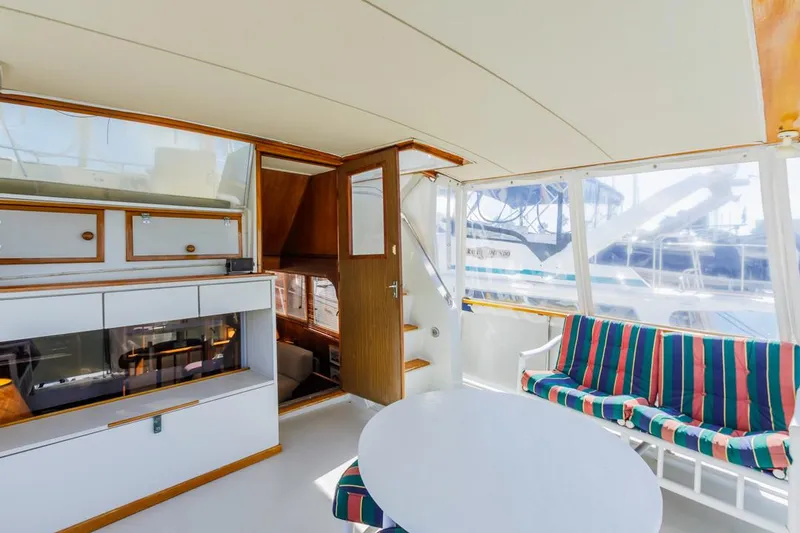 Slide: The Image of 1983 Uniflite 42 Aft Cabin interior with striped seating and round table. - 11
