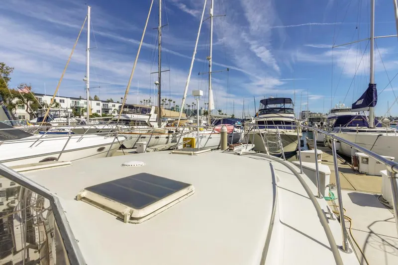 Slide: The Image of 1983 Uniflite 42 Aft Cabin yacht docked in a marina under clear blue skies. - 12