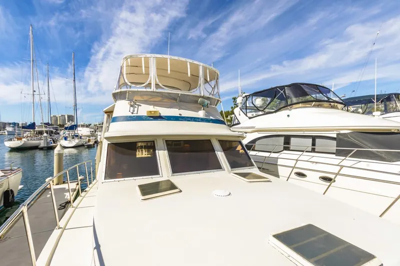 Slide: The Image of 1983 Uniflite 42 Aft Cabin yacht docked in a marina under a blue sky. - 14