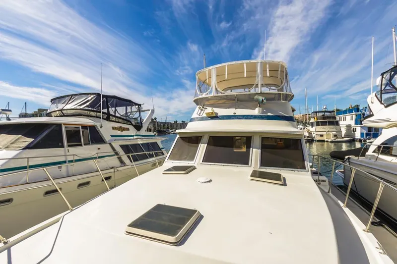 Slide: The Image of 1983 Uniflite 42 Aft Cabin yacht docked in a marina under a clear blue sky. - 15