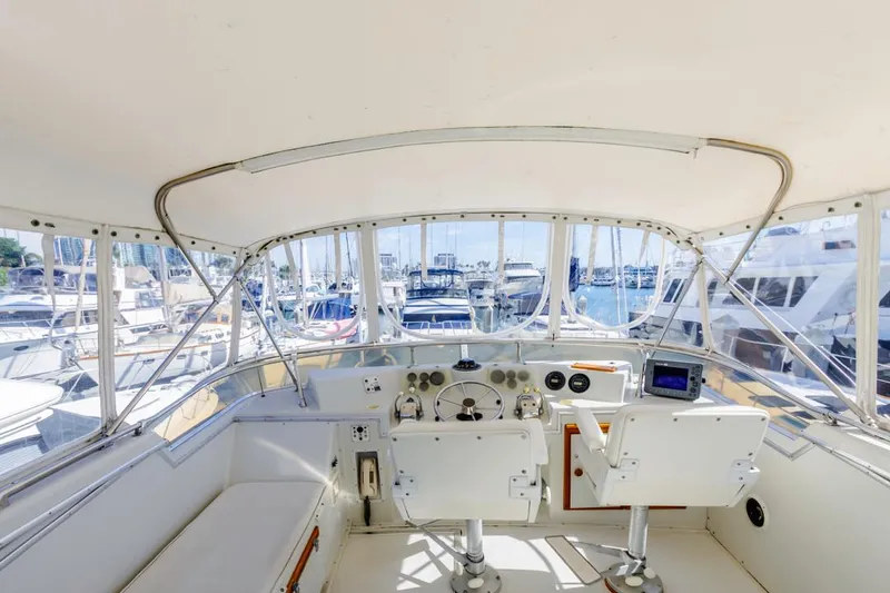 Slide: The Image of 1983 Uniflite 42 Aft Cabin yacht helm with marina view. - 19