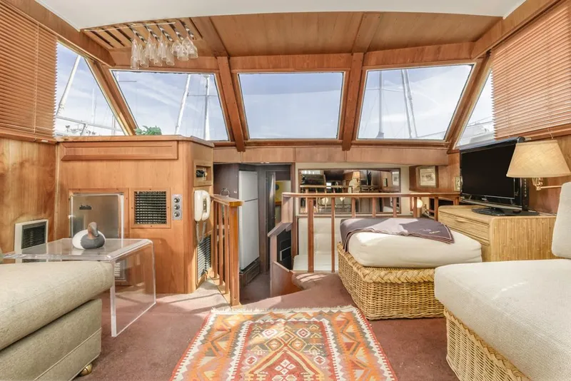 Slide: The Image of 1983 Uniflite 42 Aft Cabin interior with cozy seating, large windows, and elegant decor. - 26