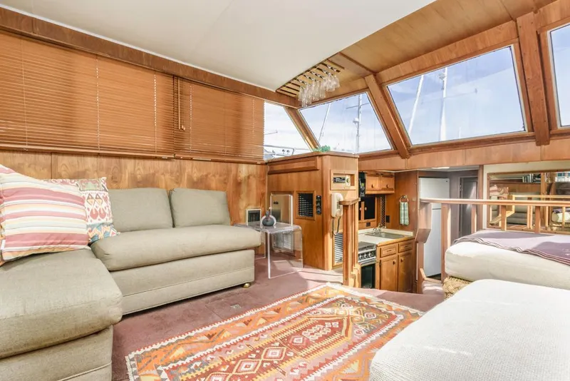 Slide: The Image of 1983 Uniflite 42 Aft Cabin interior with cozy seating and nautical decor. - 27