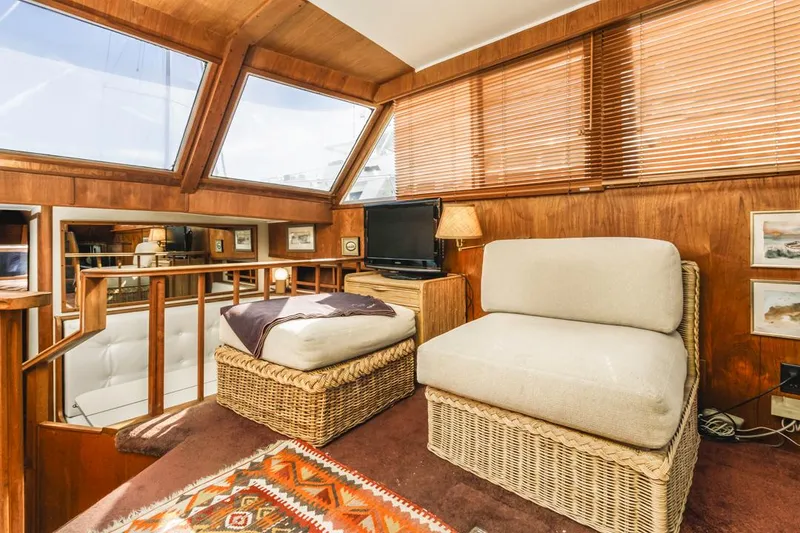 Slide: The Image of Cozy 1983 Uniflite 42 Aft Cabin interior with wicker seating and nautical decor. - 28