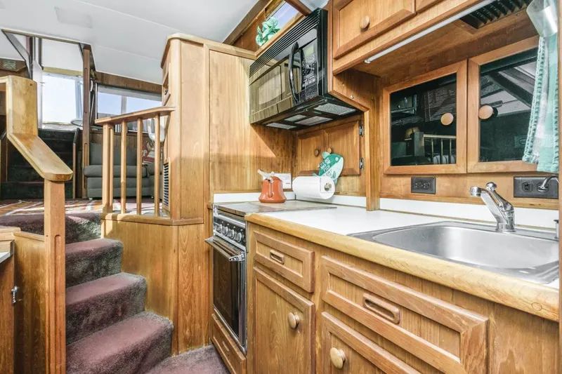 Slide: The Image of 1983 Uniflite 42 Aft Cabin kitchen with wood cabinetry and modern appliances. - 31