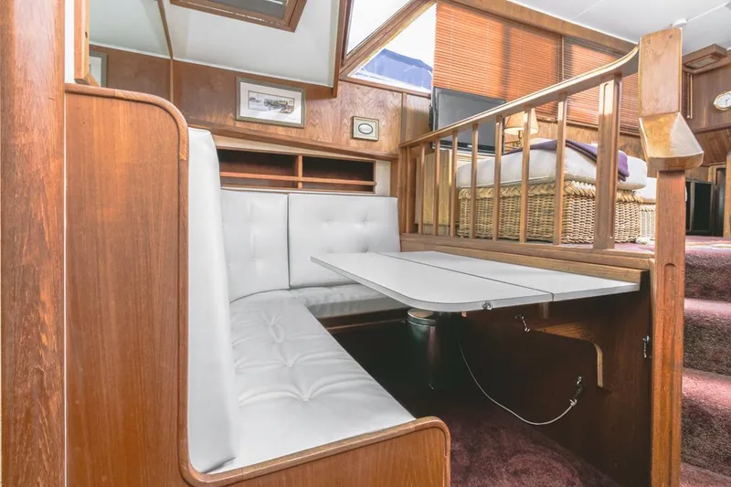 Slide: The Image of 1983 Uniflite 42 Aft Cabin interior with white seating and wooden accents. - 32