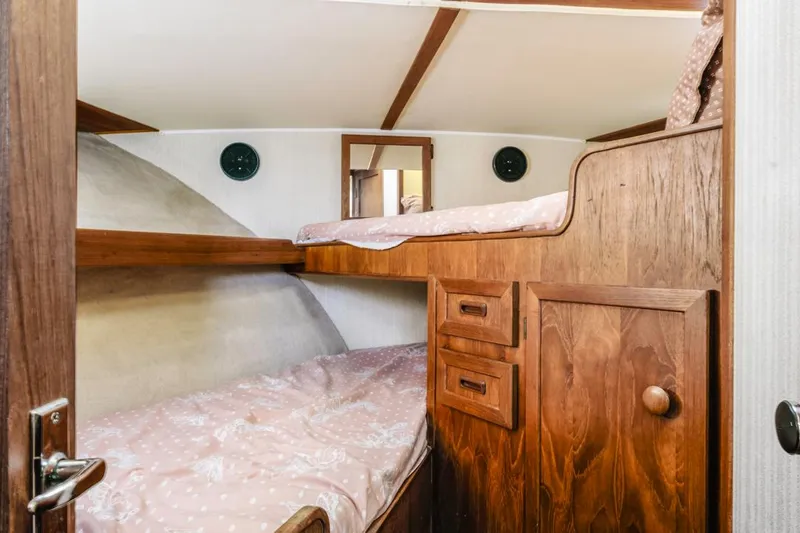 Slide: The Image of 1983 Uniflite 42 Aft Cabin interior with wooden bunk beds and storage. - 34