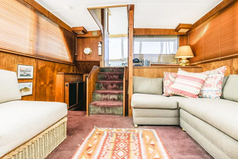 Slide: The Image of 1983 Uniflite 42 Aft Cabin interior with cozy seating and vintage decor. - 36