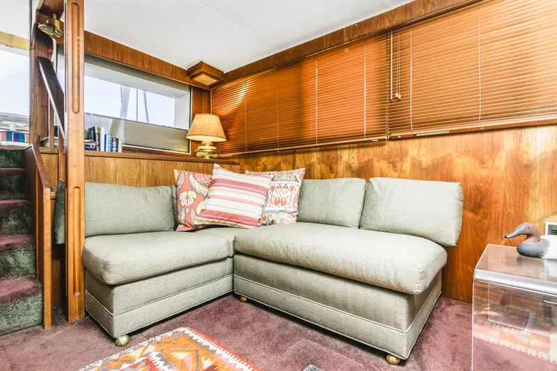 Slide: The Image of Cozy interior of 1983 Uniflite 42 Aft Cabin with sectional sofa and wooden paneling. - 37