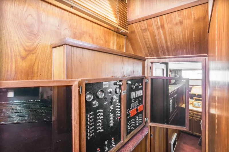 Slide: The Image of 1983 Uniflite 42 Aft Cabin interior with control panels and wood paneling. - 38