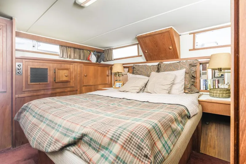 Slide: The Image of 1983 Uniflite 42 Aft Cabin bedroom with plaid bedding and wooden interior. - 40