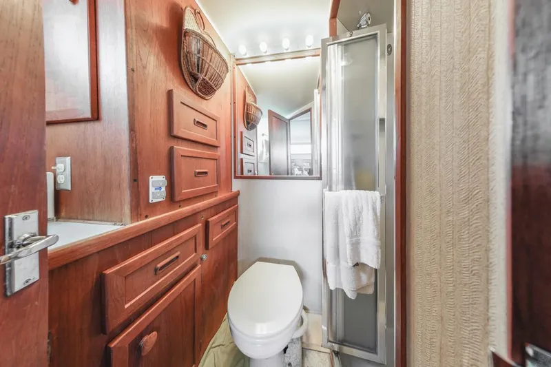 Slide: The Image of 1983 Uniflite 42 Aft Cabin bathroom with wood cabinetry and shower. - 42