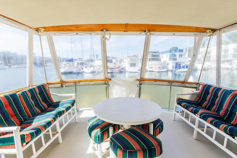 Slide: The Image of 1983 Uniflite 42 Aft Cabin yacht interior with colorful seating and marina view. - 7