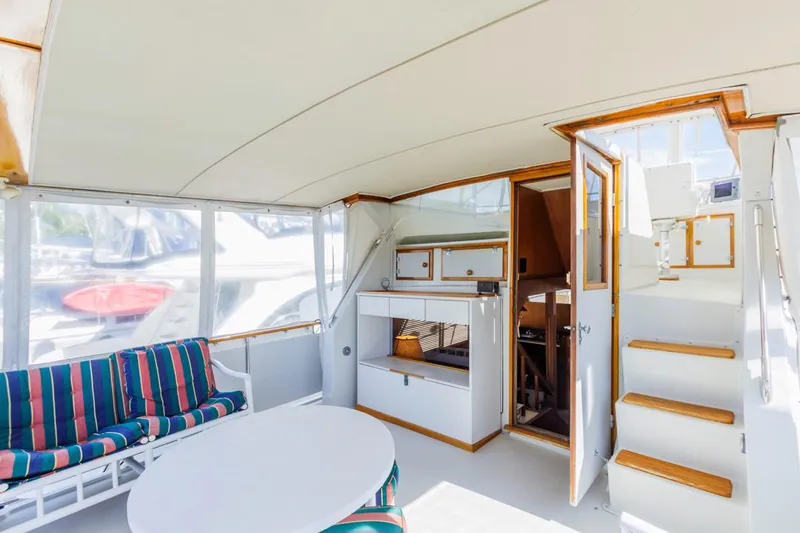 Slide: The Image of 1983 Uniflite 42 Aft Cabin interior with striped seating and wooden stairs. - 9