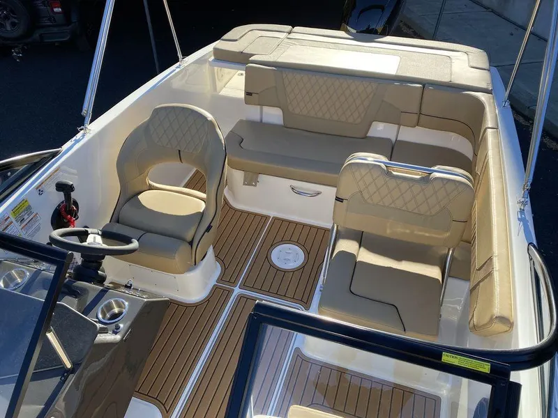 Slide: The Image of 2025 Bayliner VR5 Outboard interior with beige seating and wood-style flooring. - 12