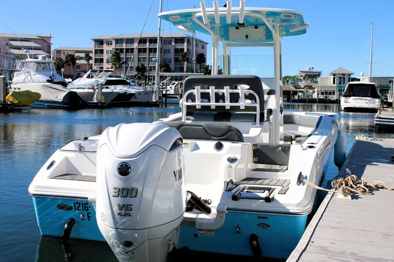 Slide: The Image of 2023 NauticStar 24 XS boat docked in marina with Yamaha 300 V6 engine. - 2