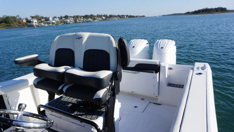 Slide: The Image of 2024 Tidewater 256 CC Adventure boat with dual engines on a scenic waterway. - 10