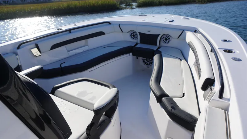 Slide: The Image of 2024 Tidewater 256 CC Adventure boat interior with cushioned seating and speakers. - 13