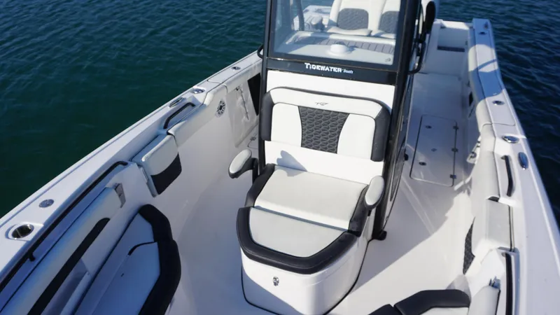 Slide: The Image of 2024 Tidewater 256 CC Adventure boat interior with seating, on calm water. - 14