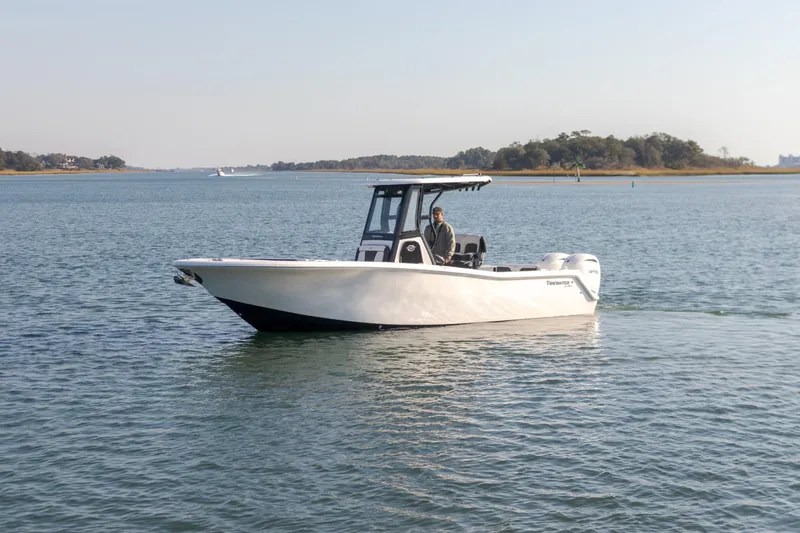 Slide: The Image of 2024 Tidewater 256 CC Adventure boat cruising on calm waters. - 4