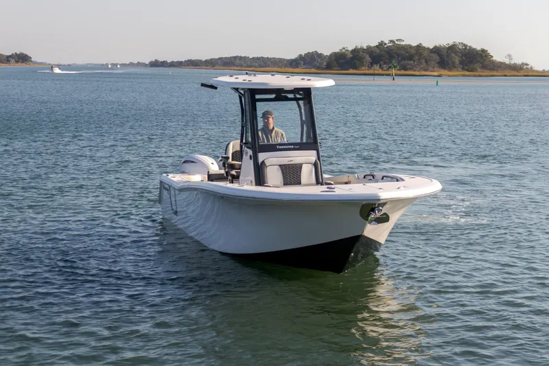 Slide: The Image of 2024 Tidewater 256 CC Adventure boat cruising on calm waters. - 6