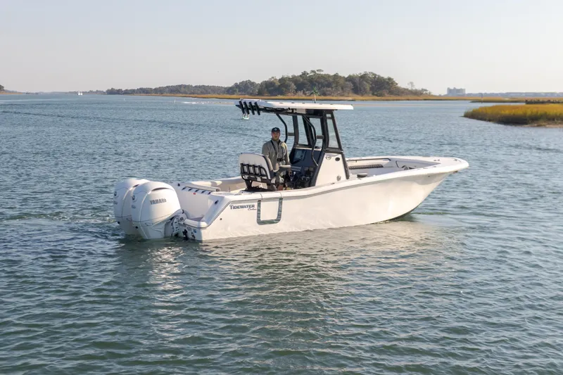 Slide: The Image of 2024 Tidewater 256 CC Adventure boat cruising on calm waters. - 8