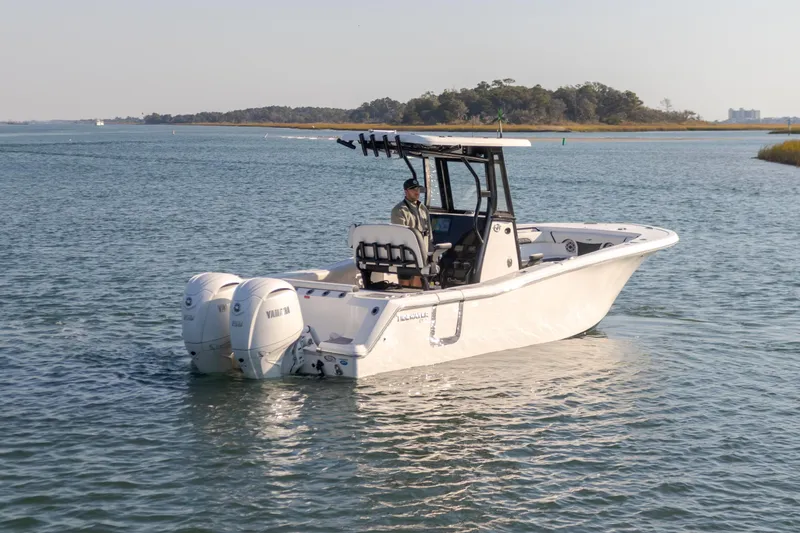 Slide: The Image of 2024 Tidewater 256 CC Adventure boat cruising on a calm lake. - 9