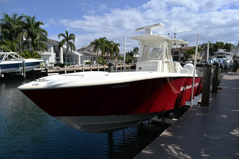 Slide: The Image of 2016 SeaVee 340Z boat docked in a marina, featuring a sleek red hull. - 1