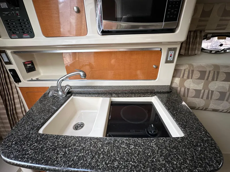 Slide: The Image of 2007 Chaparral Signature 270 kitchen with sink, stovetop, and microwave. - 6
