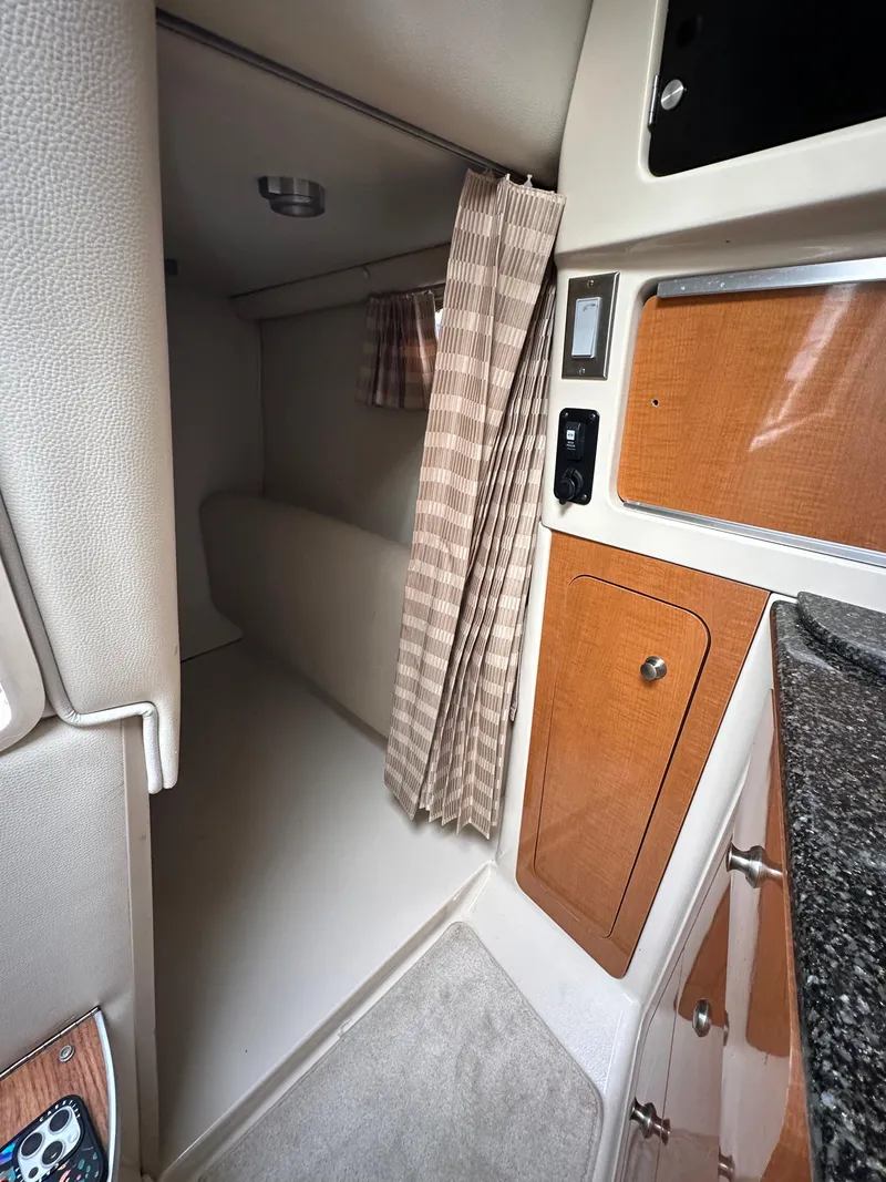 Slide: The Image of 2007 Chaparral Signature 270 cabin interior with wood accents and cozy sleeping area. - 7