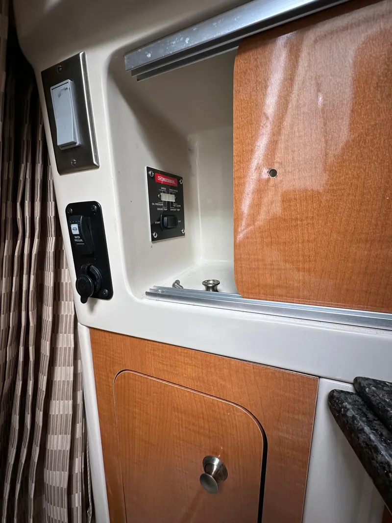 Slide: The Image of 2007 Chaparral Signature 270 interior cabin with wood paneling and control panel. - 8