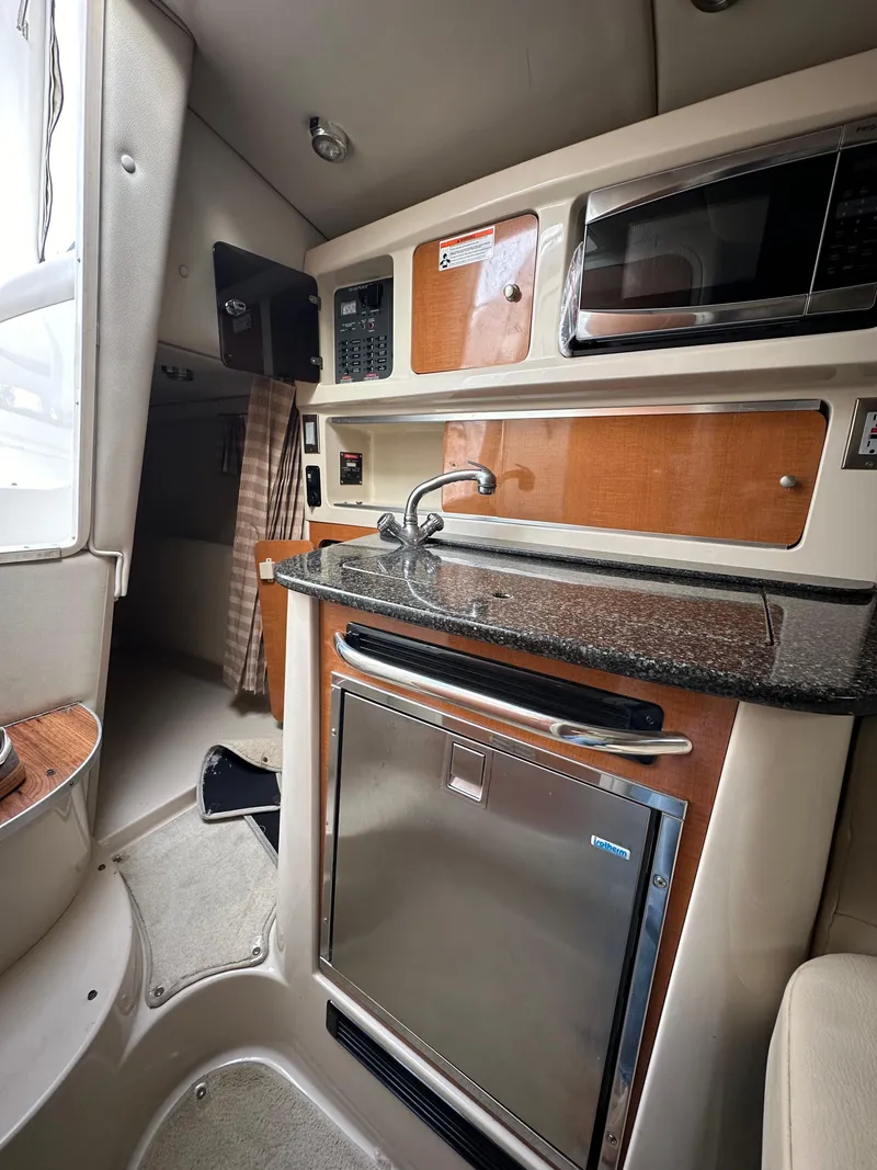 Slide: The Image of 2007 Chaparral Signature 270 interior with kitchenette, microwave, and compact fridge. - 9