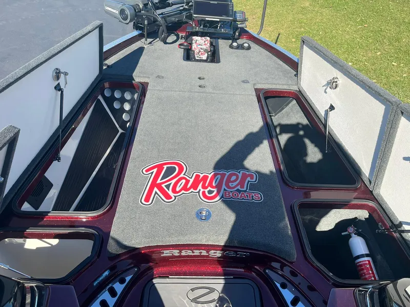Slide: The Image of 2015 Ranger Z521 Comanche boat deck with storage compartments open, featuring Ranger Boats logo. - 23
