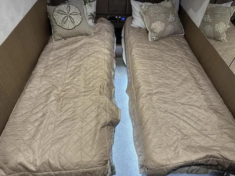 Slide: The Image of Twin beds in 2019 Galeon 650 Sky yacht cabin with beige bedding and decorative pillows. - 16