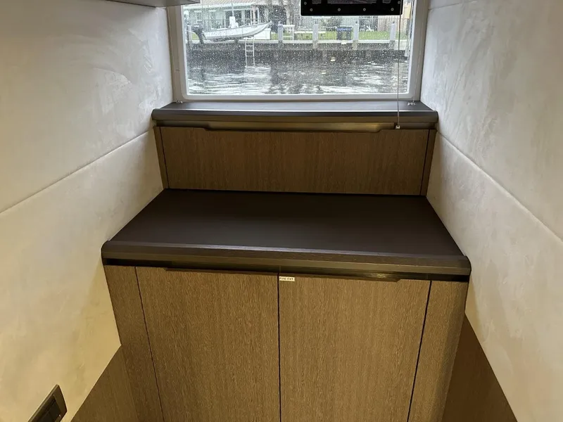 Slide: The Image of Interior of 2019 Galeon 650 Sky yacht with wooden cabinetry and window view. - 20